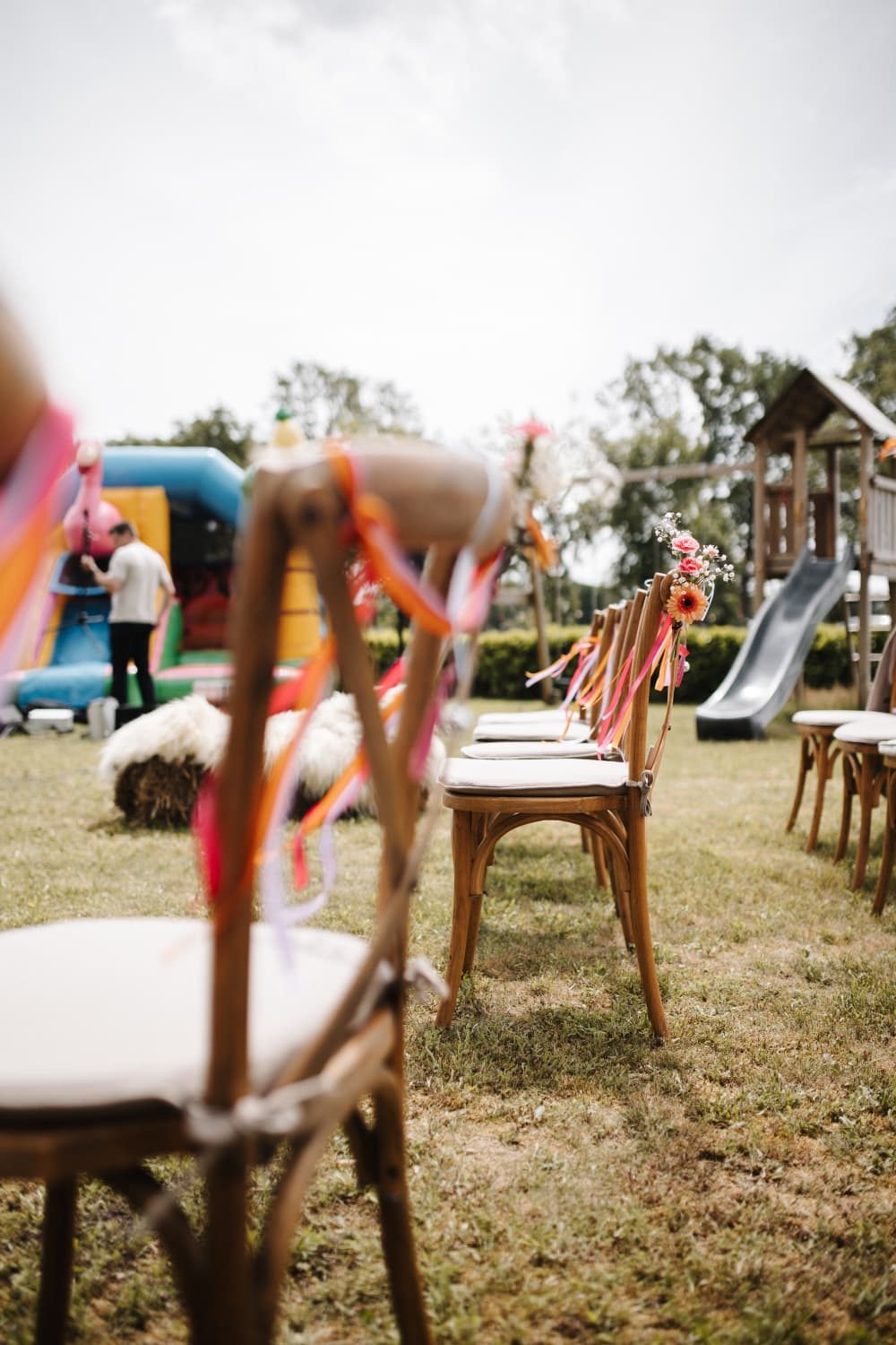 Rijen stoelen met linten op het gras